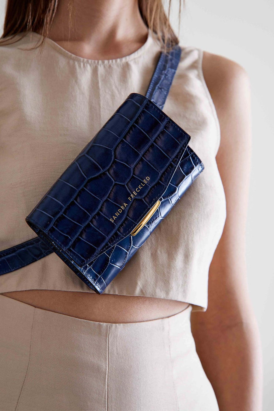 MACARENA Bolso de piel de cocodrilo en color azul marino con correa y cierre dorado. Es un bolso estilo riñonera y bandolera que puede utilizarse como bolso de mano - SANDRA FRECKLED bolsos de mujer