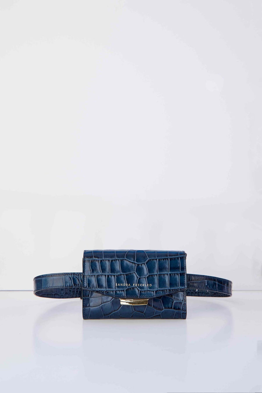 MACARENA Bolso de piel de cocodrilo en color azul marino con correa y cierre dorado. Es un bolso estilo riñonera y bandolera que puede utilizarse como bolso de mano - SANDRA FRECKLED bolsos de mujer